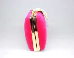 Side view of pink velvet evening clutch bag with sparkling rhinestone crown clasp