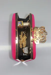 Elegant hot pink velvet evening clutch bag featuring a golden crown clasp detail