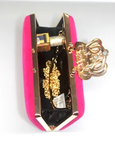Interior view showing capacity of a fuchsia velvet evening clutch with crown rhinestone clasp