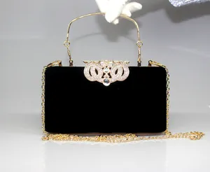Elegant black velvet evening clutch bag with ornate rhinestone crown clasp and gold chain.
