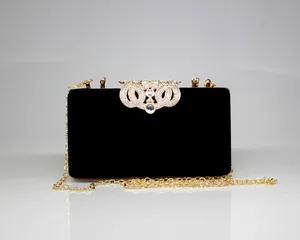 Elegant black velvet evening clutch featuring a sparkling rhinestone crown clasp and chain.