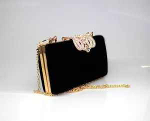 Side view of elegant black velvet evening clutch with sparkling rhinestone crown clasp