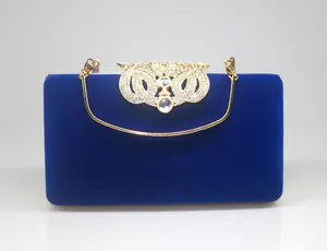 Elegant royal blue velvet evening clutch bag with sparkling rhinestone crown clasp detail
