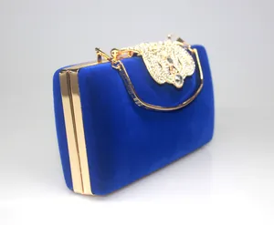 Detail view of royal blue velvet evening clutch with crown rhinestone clasp