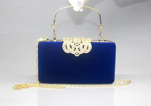 Close-up of royal blue velvet evening clutch with elegant crown rhinestone clasp