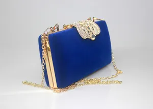 Detailed side view of a royal blue velvet evening clutch with crown rhinestone clasp