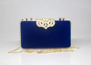 Detailed view of blue velvet evening clutch with gold crown rhinestone clasp