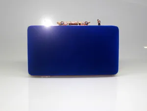Detailed view of royal blue velvet clutch bag with elegant gold crown clasp