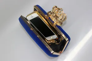 Detail view of royal blue velvet evening clutch bag with golden crown clasp capacity