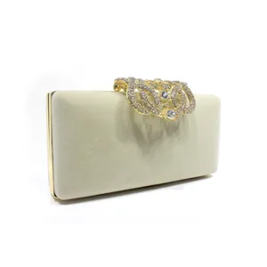 Detailed view of luxury velvet clutch bag featuring a stunning rhinestone crown clasp.