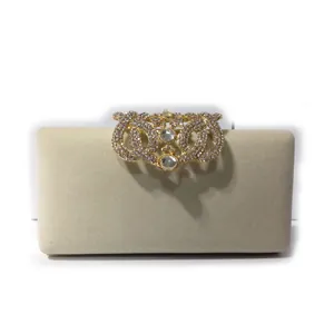 Detailed view of an elegant velvet clutch bag with a sparkling rhinestone crown clasp