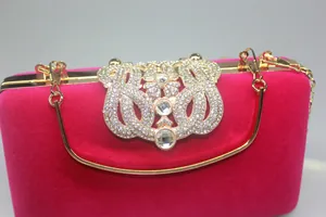 Detailed view of elegant hot pink velvet evening clutch featuring crown rhinestone clasp