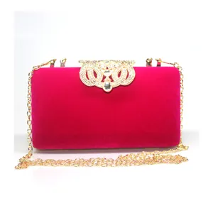 Elegant fuchsia velvet evening clutch bag featuring a luxurious gold rhinestone crown clasp