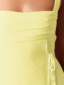 Detailed macro view of pleated bust and side tie detail on this yellow square neck dress