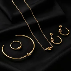 Detailed view of a gold knot jewelry set including necklace, bracelet, ring, and earrings.