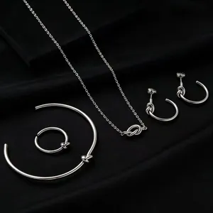 Detailed view of silver titanium steel knot jewelry set featuring necklace and earrings