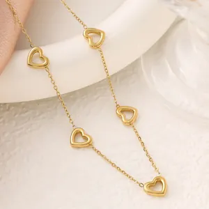 Close-up detail of golden stainless steel anklet with multiple hollow heart charms.