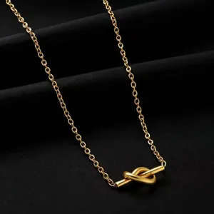 Macro detail of a high-quality gold knot pendant on a titanium steel O-chain necklace