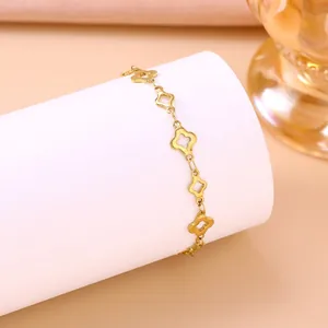 Makroansicht eines goldenen Edelstahlarmbands mit hohlem Kleeblattmuster