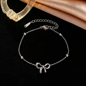 Detailweergave van zilveren titaniumstalen armband met strik en elegante kralen.