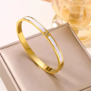 Détail d'un bracelet en acier titane plaqué or 18 carats avec nacre blanche et trois pierres