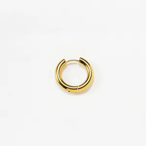 Detailansicht eines dicken goldenen Titan-Ohrrings mit einer glänzenden polierten Oberfläche