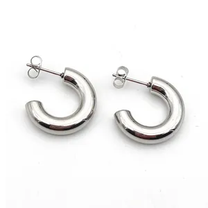 Detailed macro view of chunky silver C-shaped stainless steel high-polish stud earrings