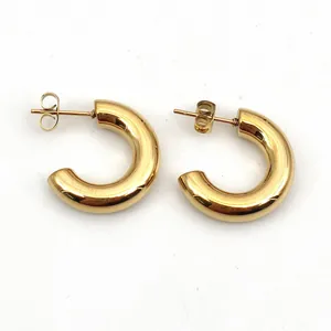 Detailed macro view of high-polished gold stainless steel C-shaped chunky hoop earrings
