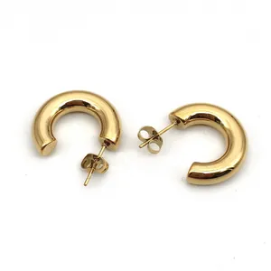 Close-up of chunky gold C-shaped stainless steel hoop earrings with polished finish