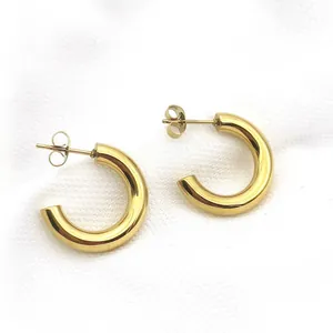 Detailed macro view of gold-plated chunky stainless steel C-shaped open hoop earrings