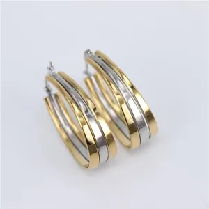 Macro view of two-tone triple layered oval hoop earrings in polished titanium steel