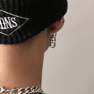Close-up of a trendy silver stainless steel chain link dangle earring worn on ear.