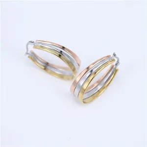 Detailed view of three-band stainless steel oval hoop earrings in tri-color finish