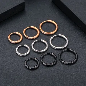 Detail view of titanium steel hoop earrings in gold, silver, and black with crystals.