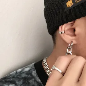 Close-up detail of stainless steel chunky chain drop earring and ear cuff on a male model