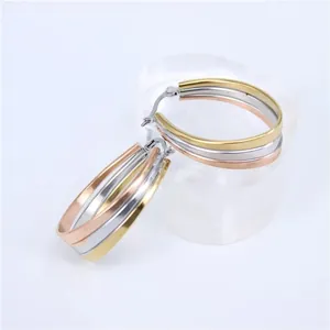 Detailed view of three-tone stainless steel oval hoop earrings with shiny metallic finish