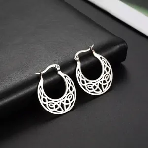 Macro view of silver-toned stainless steel hoop earrings with hollow Celtic pattern.