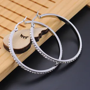 Detailed view of large silver stainless steel hoop earrings with sparkling rhinestones