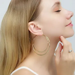 Detailansicht eines Modells mit großen goldenen doppelreihigen Edelstahl-Creolen.