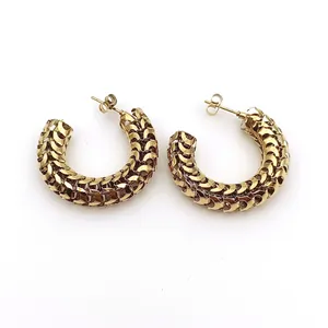 Detalle de pendientes de aro de acero inoxidable dorado con diseño de malla retro