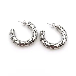 Primer plano de pendientes de aro vintage de acero inoxidable con textura de malla