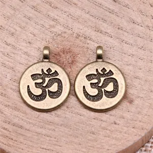 Antique bronze circular OM symbol charms for DIY jewelry making on wood background