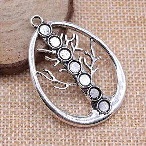 Antique silver hollow Tree of Life pendant with 7 chakra settings on a burlap background