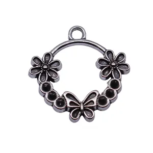 Antique silver circular alloy pendant charm with floral and butterfly motifs for DIY