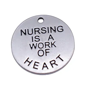 Silberner 25mm runder Anhänger mit Gravur Nursing is a work of heart.