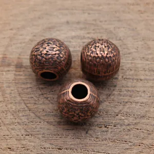 Drie antieke koperen getextureerde spacer kralen voor het maken van sieraden op houtvlak