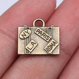 Vintage bronzen koffer bedeltje voor DIY sieraden maken met diverse stadsreislabels