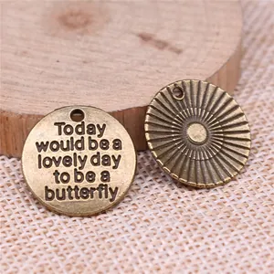Ronde 20mm bronzen hanger met vlinder tekst en zonnestraal patroon achterkant