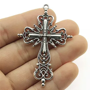 Ornate vintage silver cross pendant held in hand for DIY jewelry making accessories