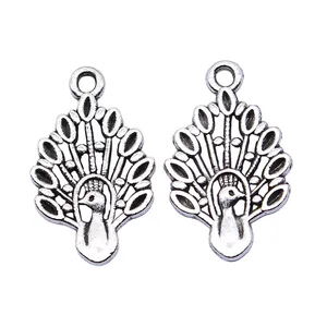 Two antique silver peacock charms for DIY jewelry making, 12x19mm size on white background